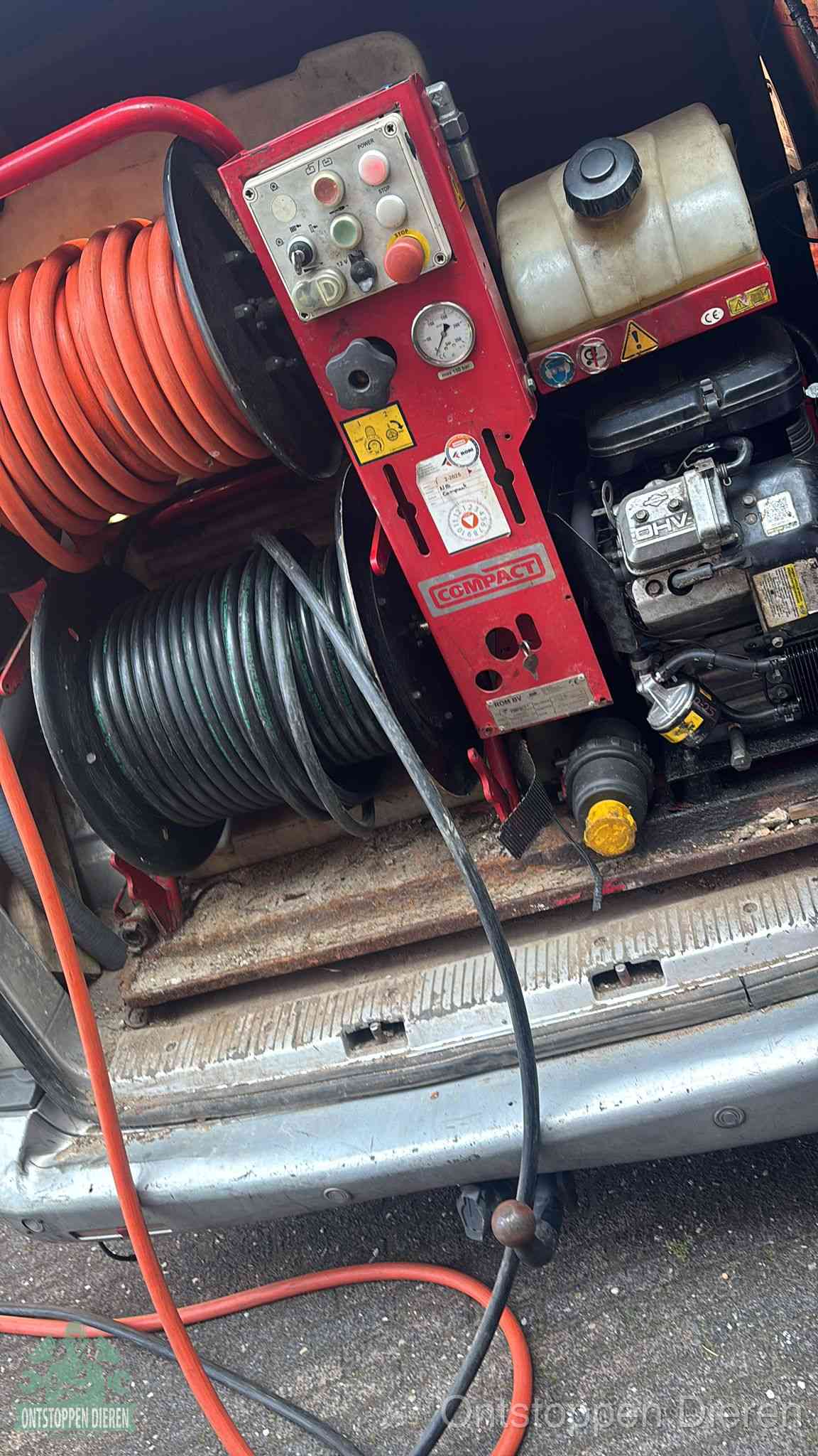 Een rood hogedruk-rioolreinigingstoestel in de laadbak van de bedrijfsbus, apparatuur voor een hardnekkige afvoerverstopping in Dieren