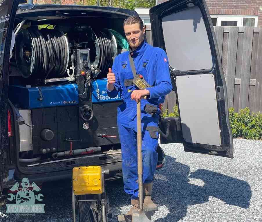 Een monteur bij de werkbus met grote hogedruk-slanghaspels, apparatuur voor hardnekkige afvoerverstoppingen in Dieren