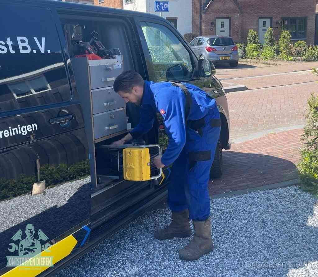 Een monteur pakt apparatuur uit de bedrijfsbus voor service aan huis, het moment om een professional in te schakelen in Dieren