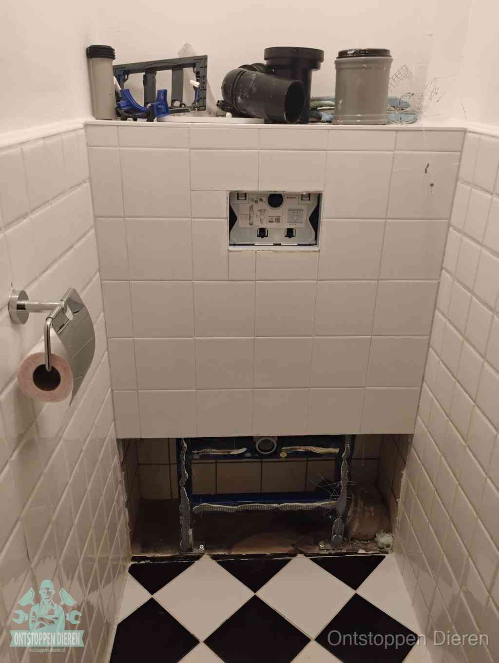 Een toiletruimte waar het hangtoilet en de inbouwreservoir-onderdelen zijn vrijgelegd voor onderhoud, periodiek nazicht voorkomt een wc-verstopping in Dieren